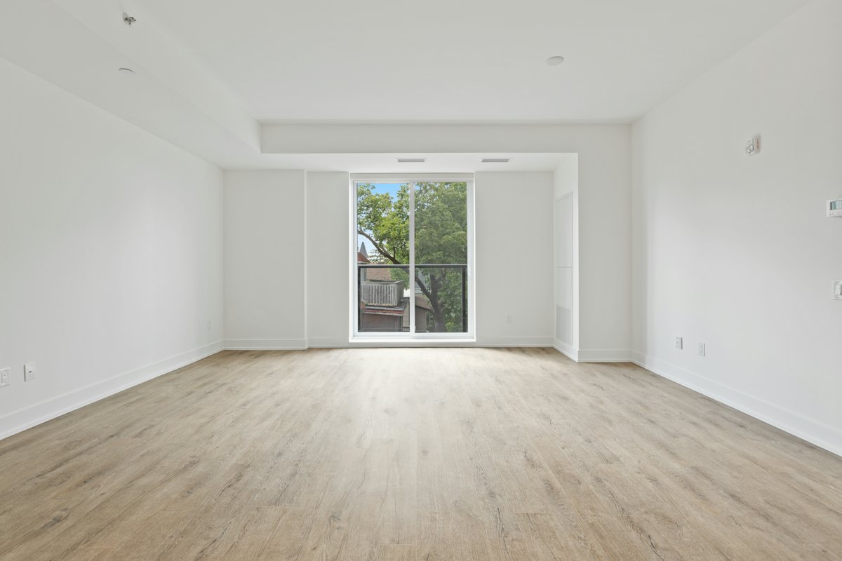 Empty living room facing a glass balcony door.